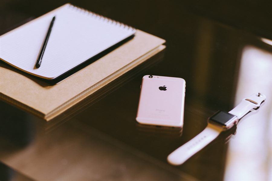 Teléfono móvil y libreta sobre escritorio de trabajo