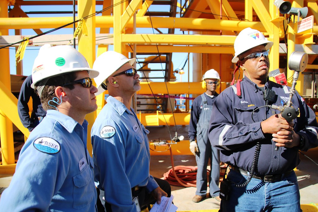 Inspector con equipo de medición y elementos de protección auditiva en sitio industrial